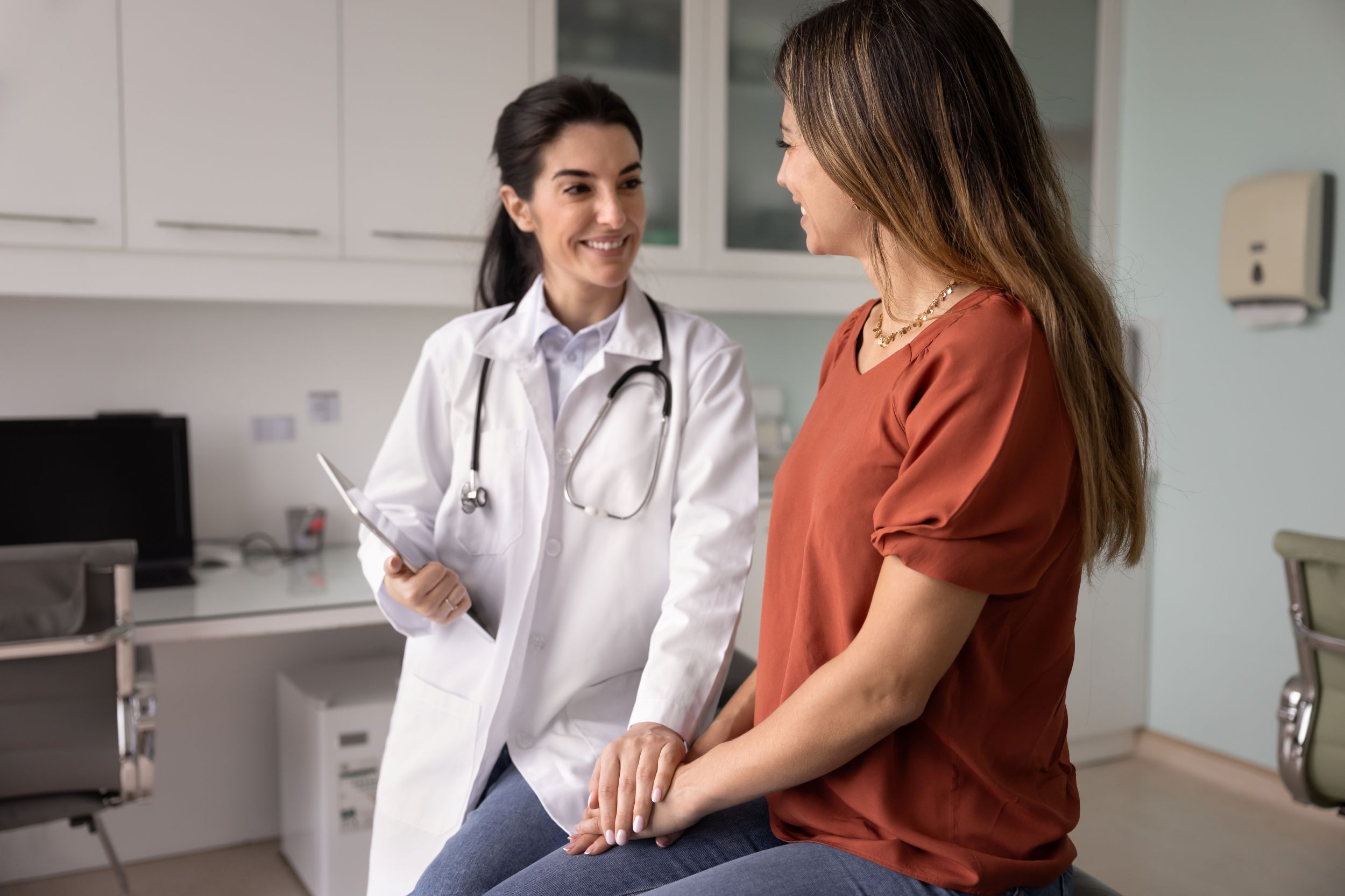 A doctor talking to a woman in a patient room